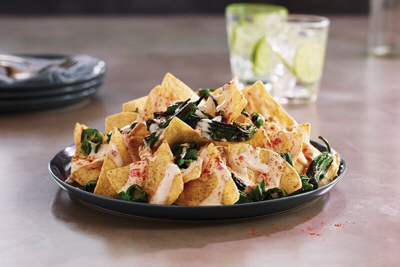 White Cheddar Shishito Nachos showcase how on-trend substitutions can take nachos in a wonderful new direction.