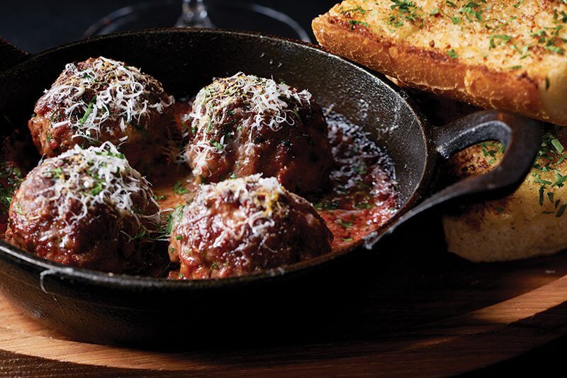 Dry-Aged Prime Beef Meatballs in a cast-iron skillet were inspired by Chef Danny Grant’s family recipe, served at Maple & Ash in Chicago.
