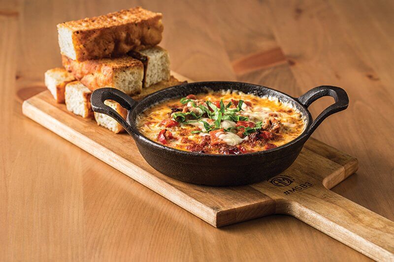 The wildly popular Oven-Baked Pizza Dip at TR Fire Grill in Winter Park, Fla., makes pizza a dippable, shareable experience, coming out bubbling and inviting in a cast-iron skillet.