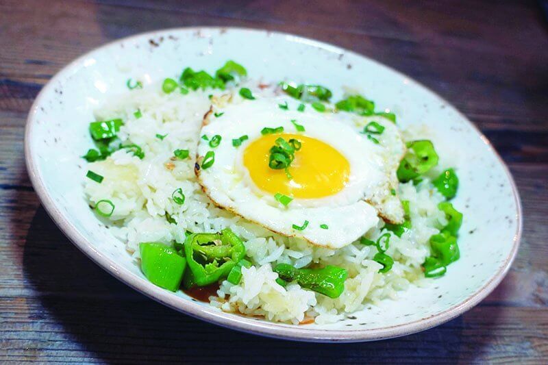 The Crispy Pearl Rice at The Little Beet Table in Chicago incorporates shishito peppers and is topped with a sunny-side-up egg.