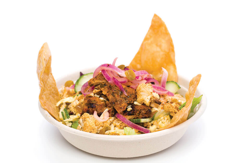 This Choolah Salad includes chicken baked in a tandoor oven, set atop power greens and a mélange of other ingredients, surrounded by naan chips. 