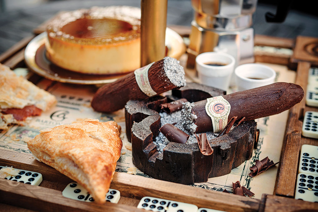 Café caramel flan, tobacco-laced gianduja chocolate cigars, guava pastelitos, café con leche dipping sauce, Cuban coffee, served on a dominoes board