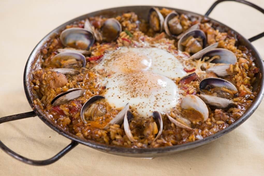 Paella With Chicken, Chorizo, Clams And Shirred Eggs