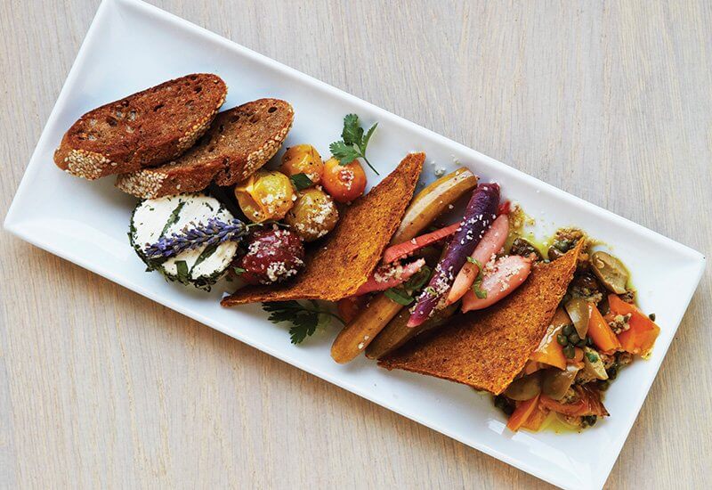 Fans of the plant-based menu at Café Gratitude in Southern California can start off their meal with an antipasto platter featuring pickled market vegetables, oven-roasted tomatoes and cultured macadamia cheese with white truffle.