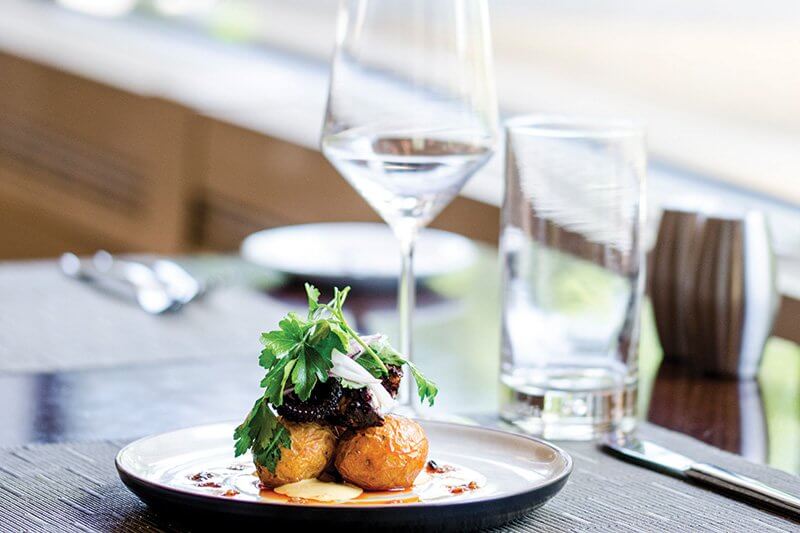 Baby Yukon potatoes are roasted in a salt crust then deep fried and tossed with paprika oil at Vinifera in Reston, Va., accenting plancha-seared Spanish octopus.