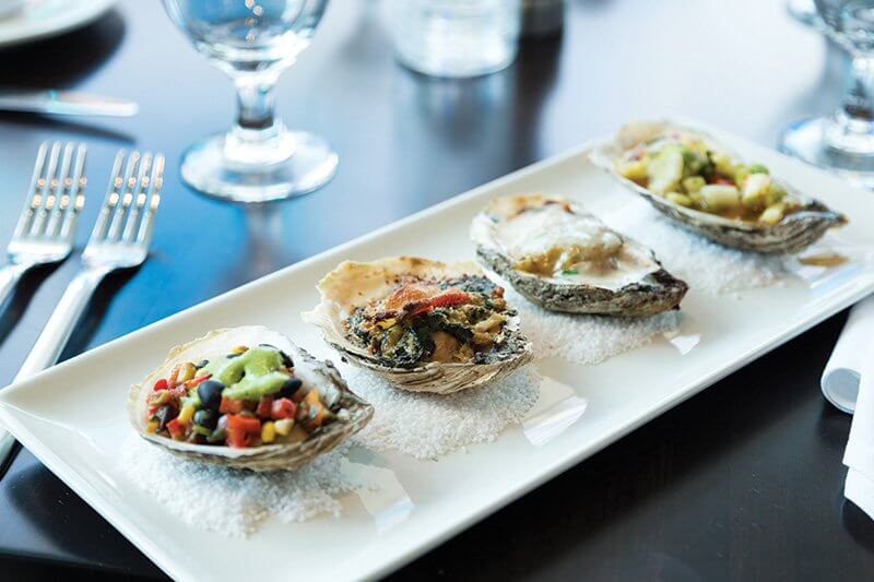 Grilled Oyster Co. adds signature flavor appeal to its grilled oyster flight, including toppings of barbecue sauce and chilled cucumber relish, or roasted turnips, carrots, radishes and guajillo salsa.