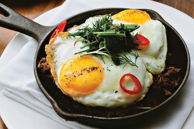 The brunch boom has brought renewed interest to skillet dishes like this Short Rib Hash, with braised beef short rib, eggs, home fries, peppers, onion and spinach, at Spoke & Steele in Indianapolis.