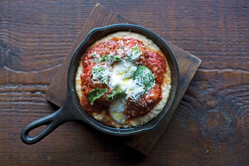 A skillet of Tomato-Braised Meatballs with burrata and grits served at Acorn in Denver, relays rustic, homey, hearty, just-for-you cues that resonate with consumers today.