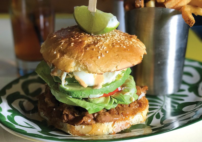 At Bodega Negra Café in New York, the decadent Crispy Pork Belly Torta stars refried cowboy beans, queso Oaxaca, and a fried egg.