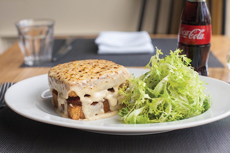 A blanket of luxurious Mornay sauce coats the croque monsieur at DoveCote in Orlando, Fla.