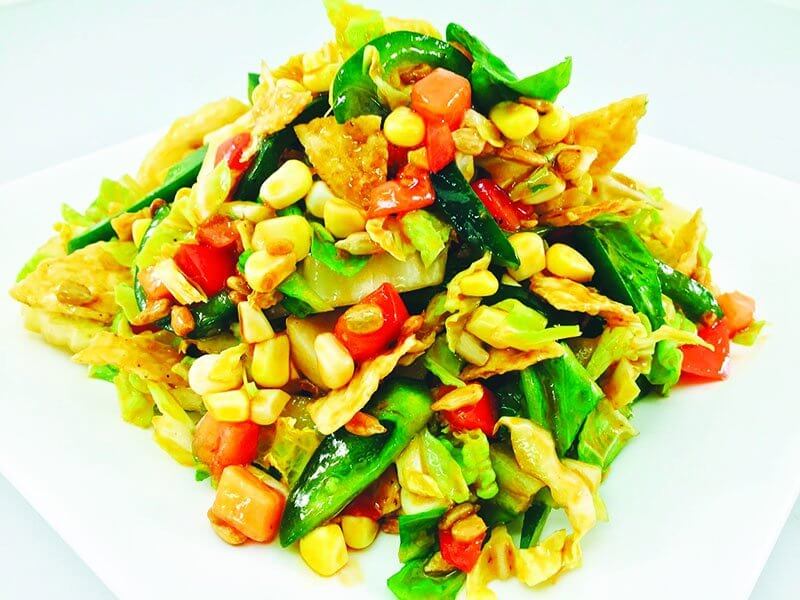 Unforked’s Crunchy Q Salad sees romaine and napa cabbage, crushed white corn chips, raw sweet corn, poblano chiles, roasted sunflower kernels and tomatoes.