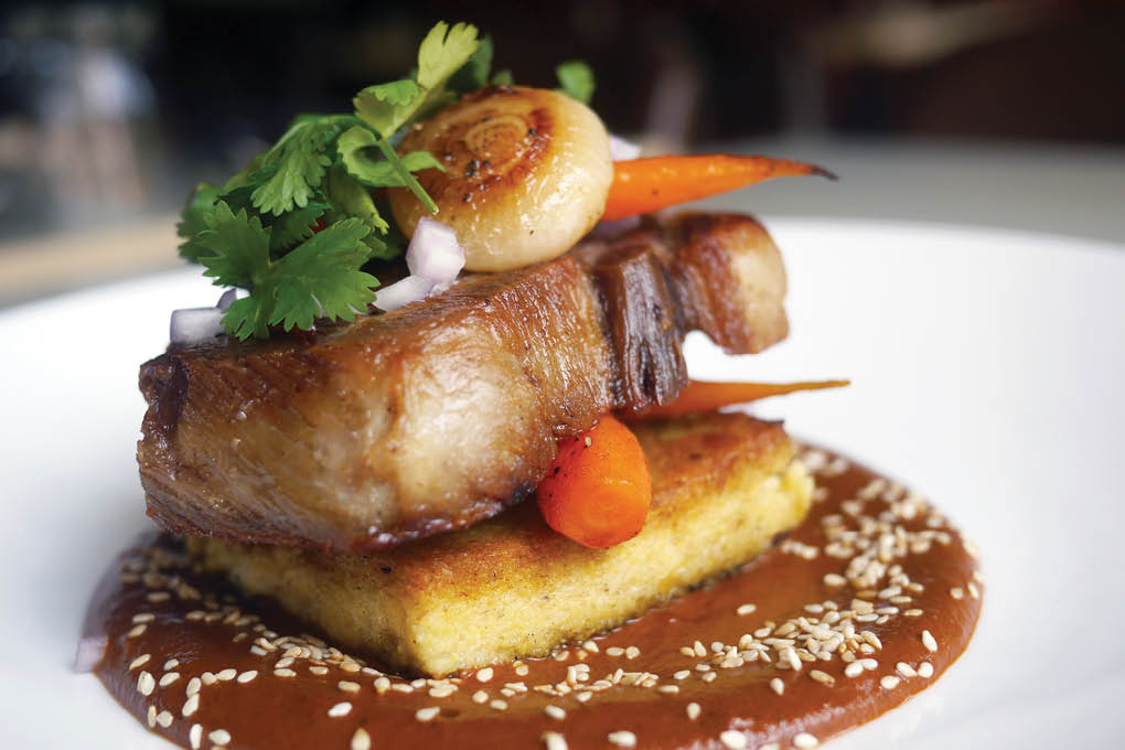 Ashlee Aubin, executive chef of Wood in Chicago, serves his braised pork collar with cipollini onions, baby carrots, red onion and cliantro.