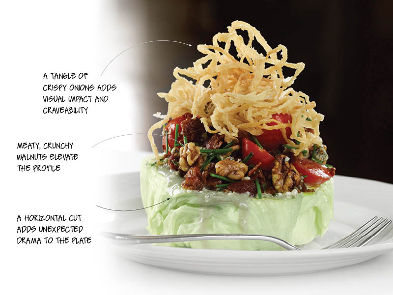 Updating the steakhouse classic, The Palm Restaurant’s Iceberg Lettuce Wedge is a striking build, with blue cheese, toasted walnuts, bacon, cherry tomatoes, chives and fried onions.