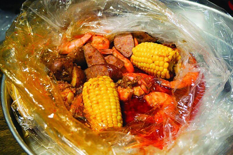 Seafood boils offer a party in a bag. Shellfish and sides can be customized, such as shrimp with corn, potato and sausage at Mad Boiler in Chicago.
