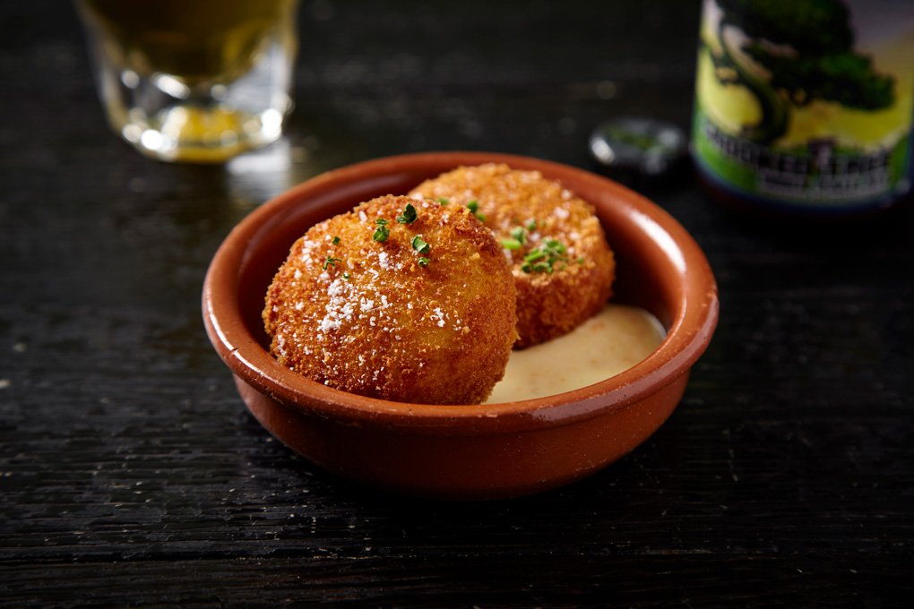 CROQUETTES OF SLOW-COOKED SMOKED PORK AND CHEESE, SERVED WITH MOJO VERDE, ARE ON THE PINTXOS MENU AT SALERO IN CHICAGO