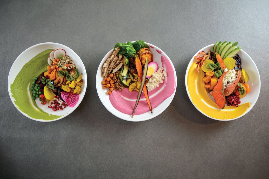 A rich and colorful swipe of hummus starts the bowl-build process at Za’atar Hummus Bar. Flavors include (left to right) spring pea and spinach, beet, and charred carrot with ras el hanout. Customizable selections of add-ins complete the build.