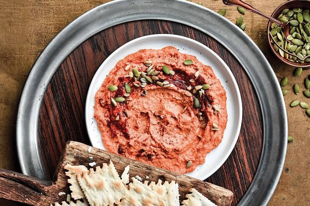 Bush’s Best® Classic Hummus Made Easy® (made with chickpeas) is blended with sun-dried tomatoes and harissa paste and topped with sunflower kernels and a ground sumac.
