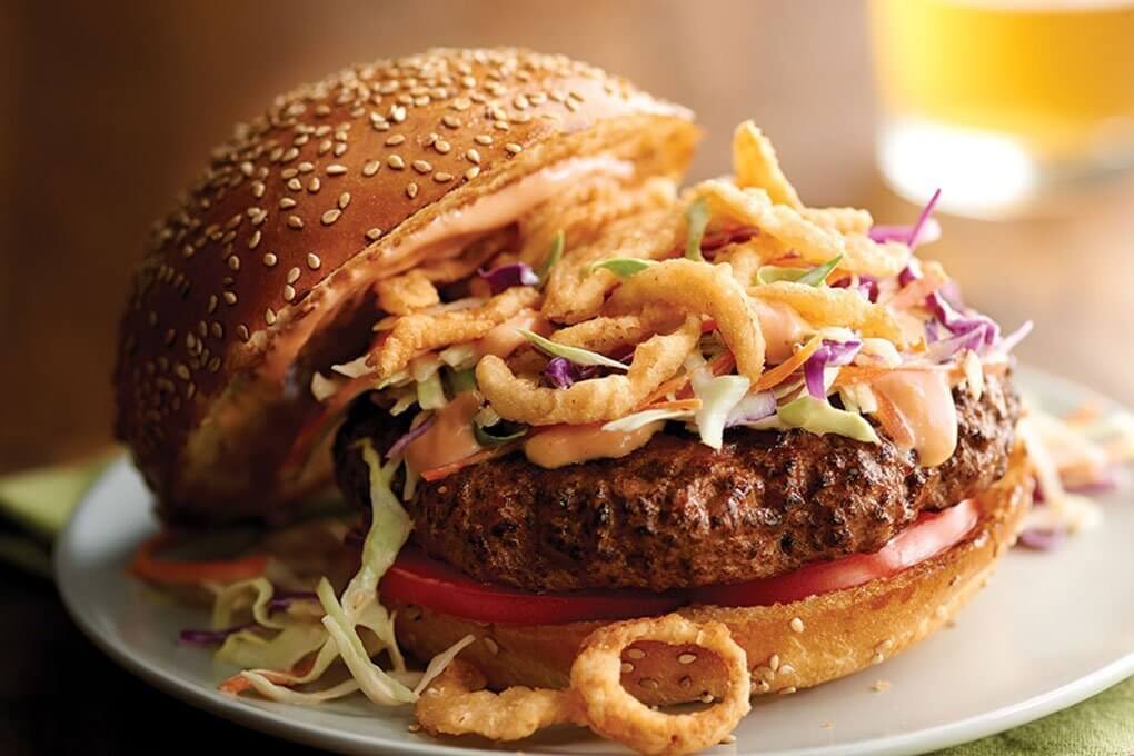 This signature house burger is topped with a crispy blend of shredded cabbage, carrot and scallions tossed with French's® Crispy Fried Onions, sesame seeds and Frank's® RedHot® Sriracha aioli