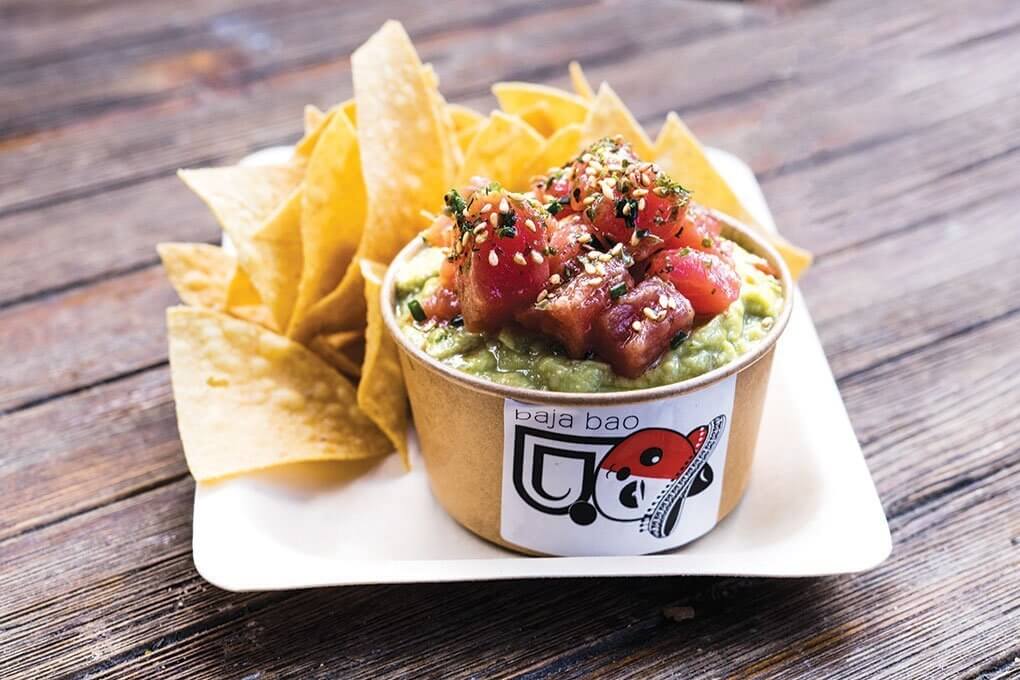 Miami’s Baja Bao House stars Jose Mendin’s take on global street food. Here, his Tuna Poke Guacamole showcases poke’s reach, featured over guacamole and served with chips as a premium bar snack.