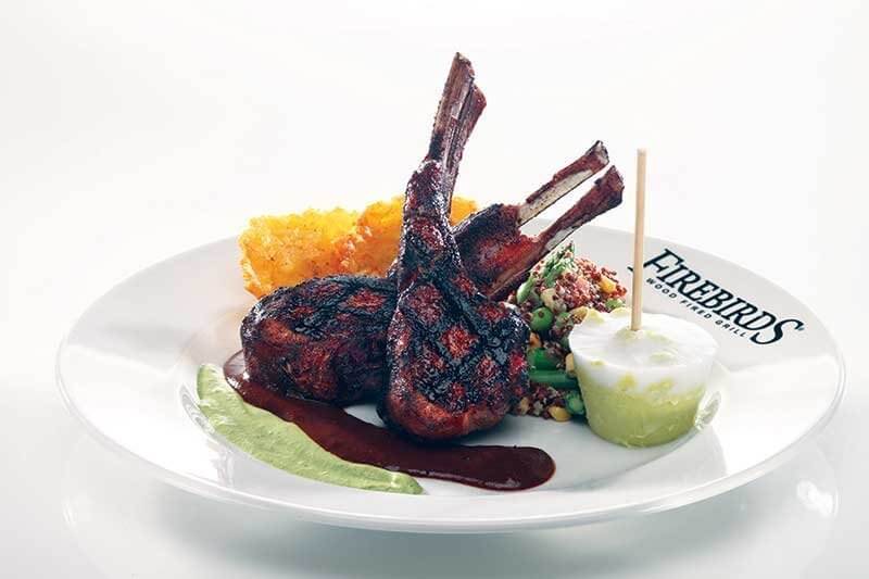 Firebirds Wood Fired Grill’s Aussie 
Guajillo-Mocha Rubbed Lamb Chops entrée demonstrates a modern approach, with flavor punches throughout the build, including a pumpkin-seed pesto and ancho demi. 