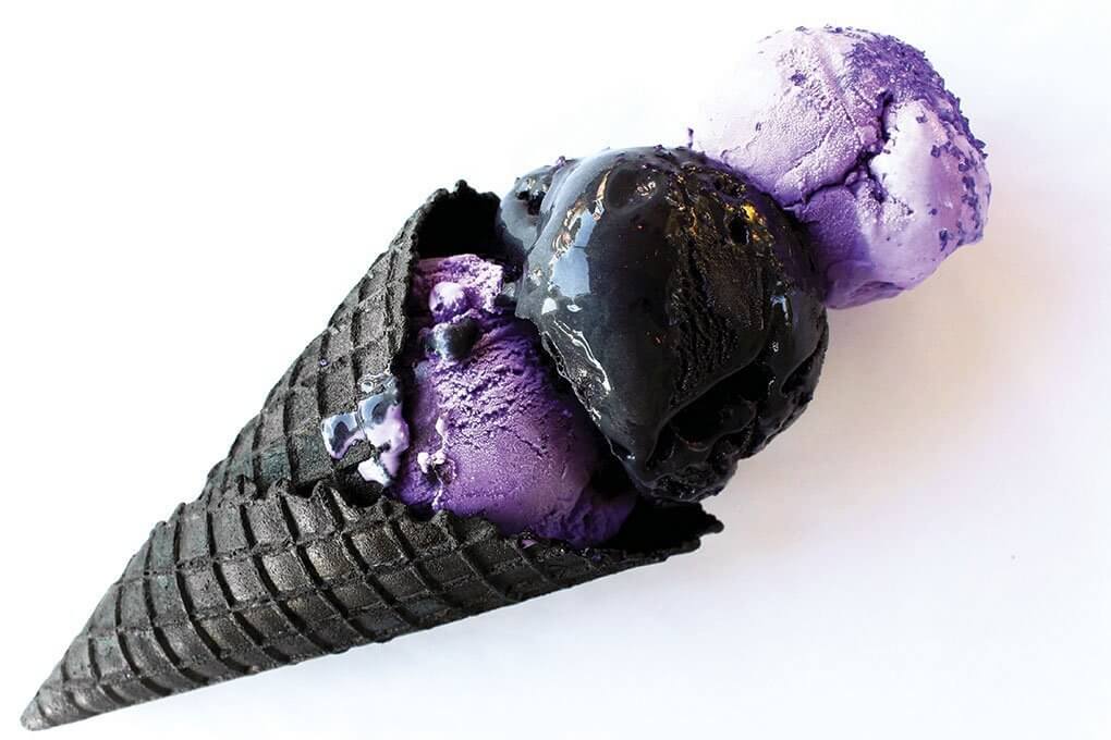 Dough’s Ultra Violet Ice Cream not only stuns with vibrant color, but delivers a unique flavor experience of green tea and pomegranate, paired here with a scoop of Galaxy—black ice cream with coconut ash and edible glitter.
