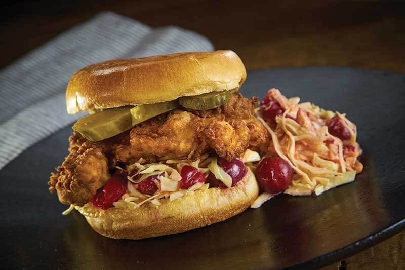 This Sorghum Fried Chicken Sandwich stars a creative cabbage slaw studded with tart cherries and pineapple, and spiked with hot sauce.