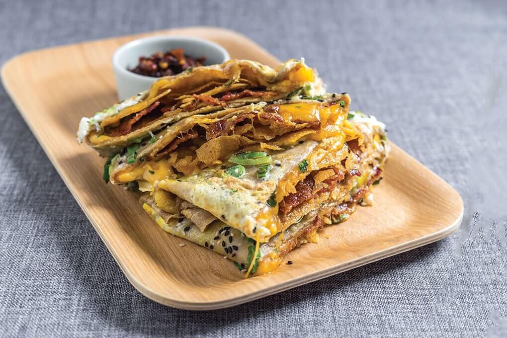 Mr Bing in New York has extended into breakfast with offerings like the Maple Bacon, Egg and Cheese Bing that blends sweet and savory flavors in a craveable crêpe-like format.