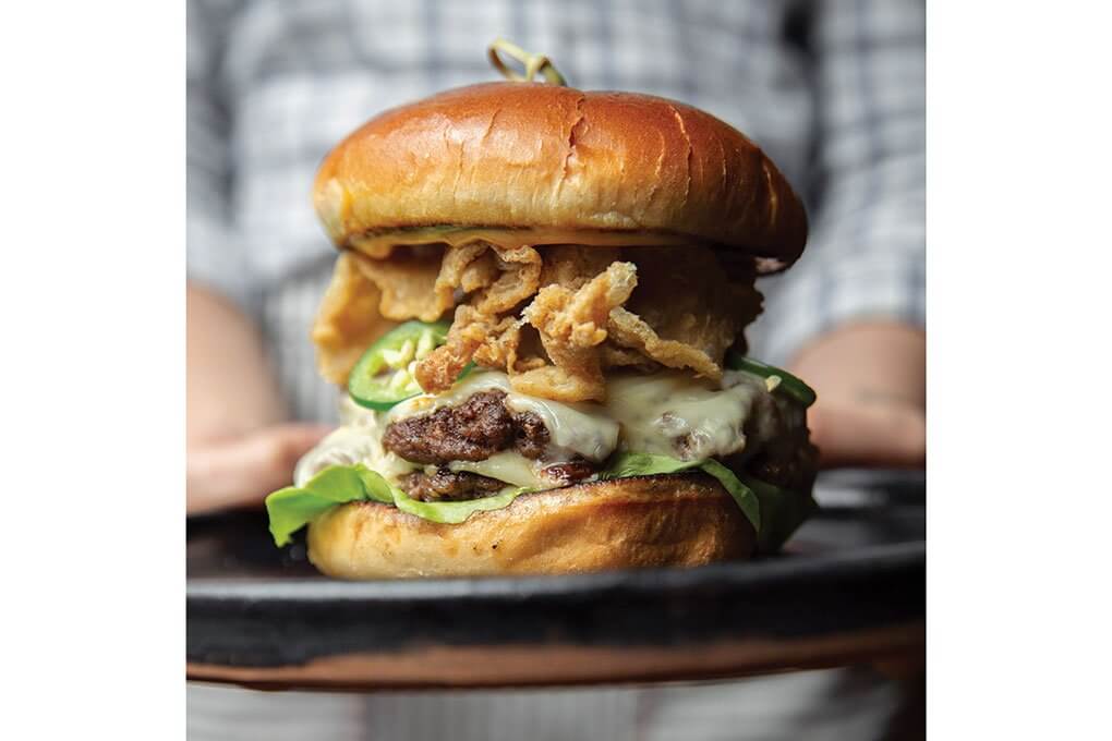 Two beef patties, smoked Gouda, Serrano pepper aïoli, lettuce, fried chicken skins, brioche bun