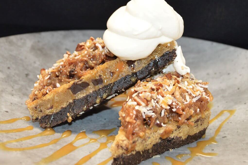 Oreo cookie crumbs, chocolate chunks, caramel blondie, cake icing, vanilla whipped cream, toasted coconut