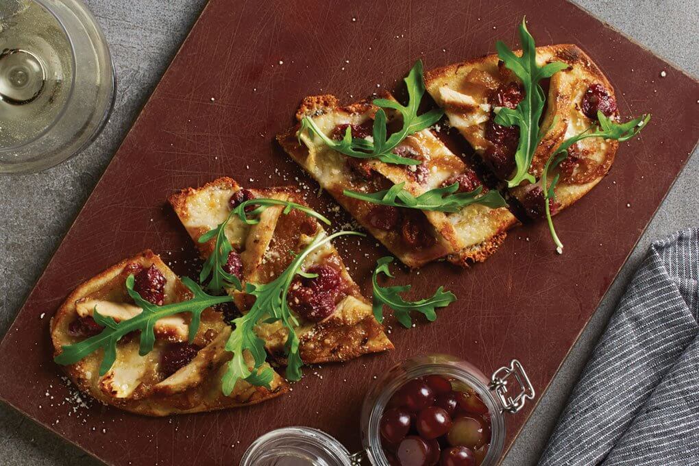 Sonoma Grilled Chicken Flatbread with double-cream Brie, caramelized onions, grilled chicken, hearth-roasted grapes, Parmesan, baby arugula
