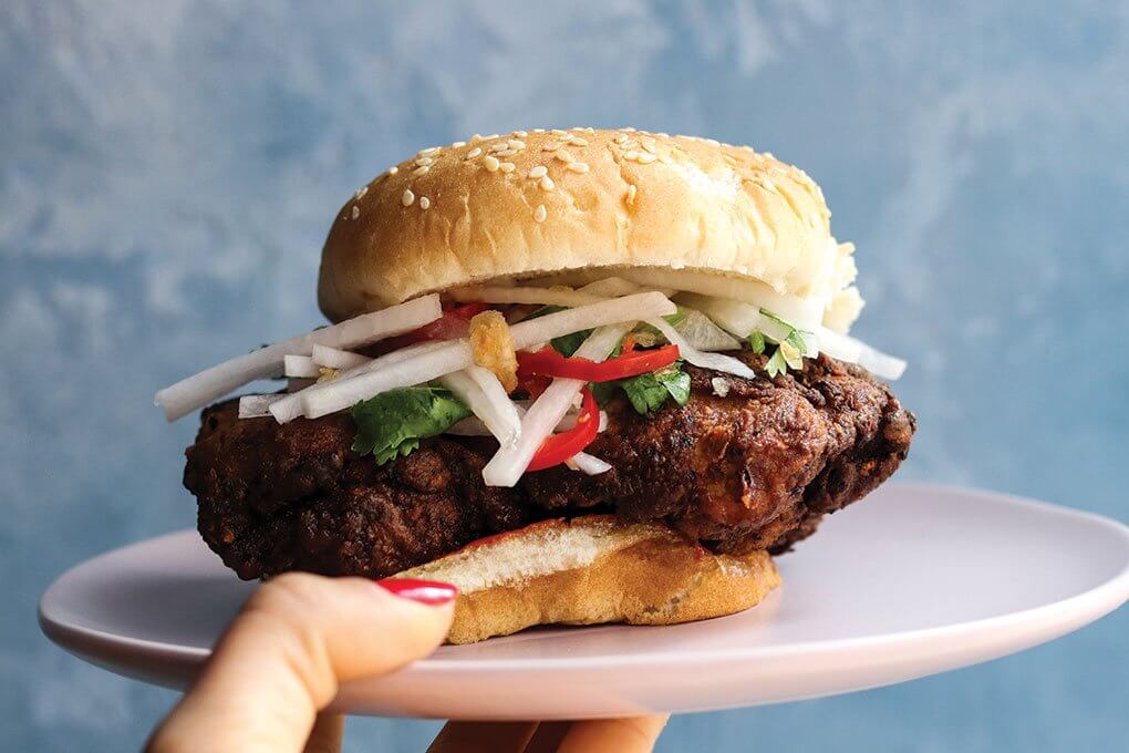 Leg of deep-fried chicken, toasted sesame bun, spicy daikon slaw