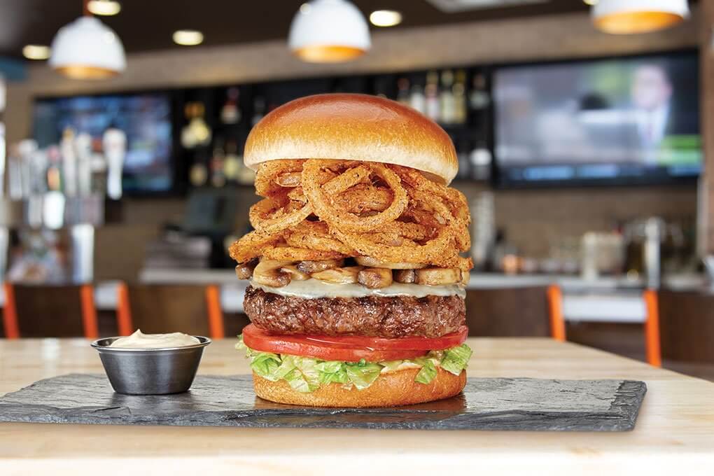 The Counter Burger with provolone, lettuce, tomato, sautéed mushrooms, crispy onion strings, roasted garlic aïoli