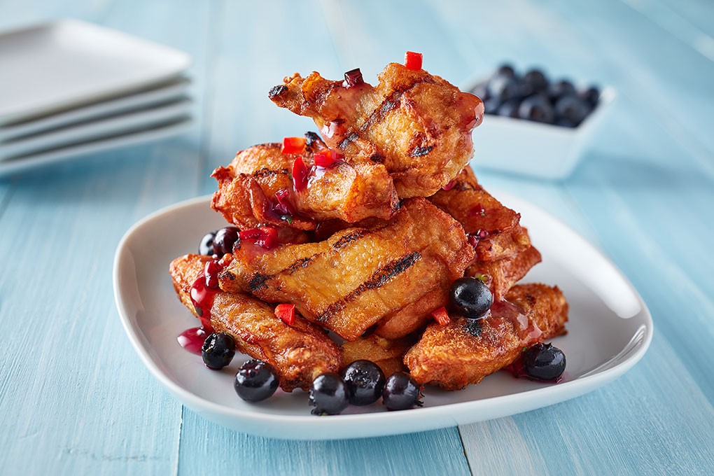 Chicken wings are tossed in a glaze of blueberries and datil peppers for a craveable sweet-heat profile.