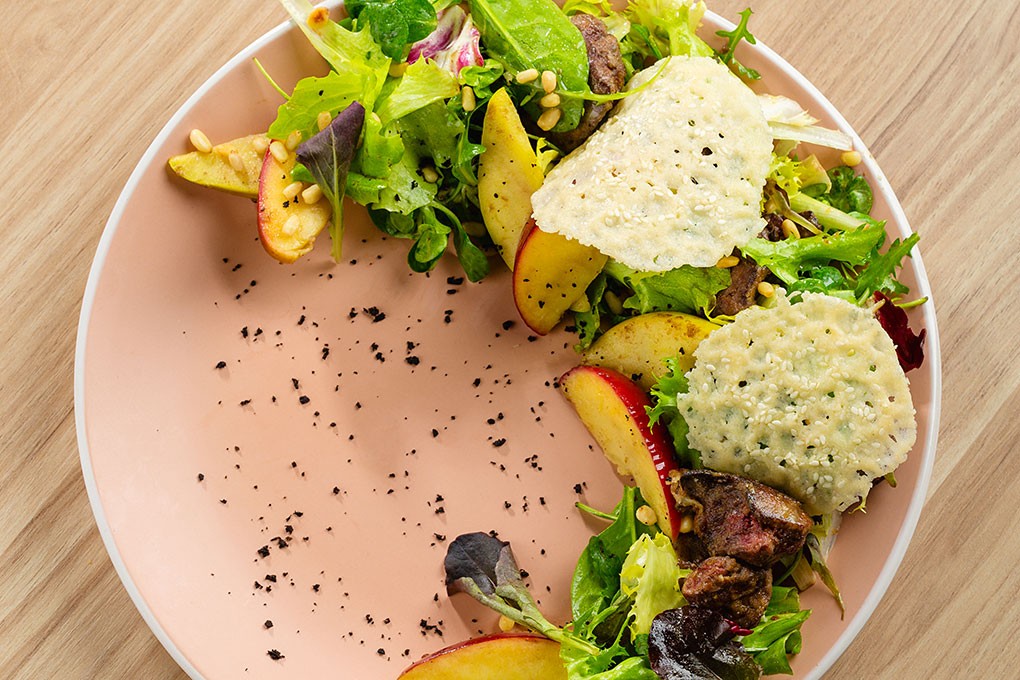 A green salad with crisp red apple and grilled steak is tossed in an apple-cider vinaigrette and topped with savory cheese crackers and a sprinkling of furikake.