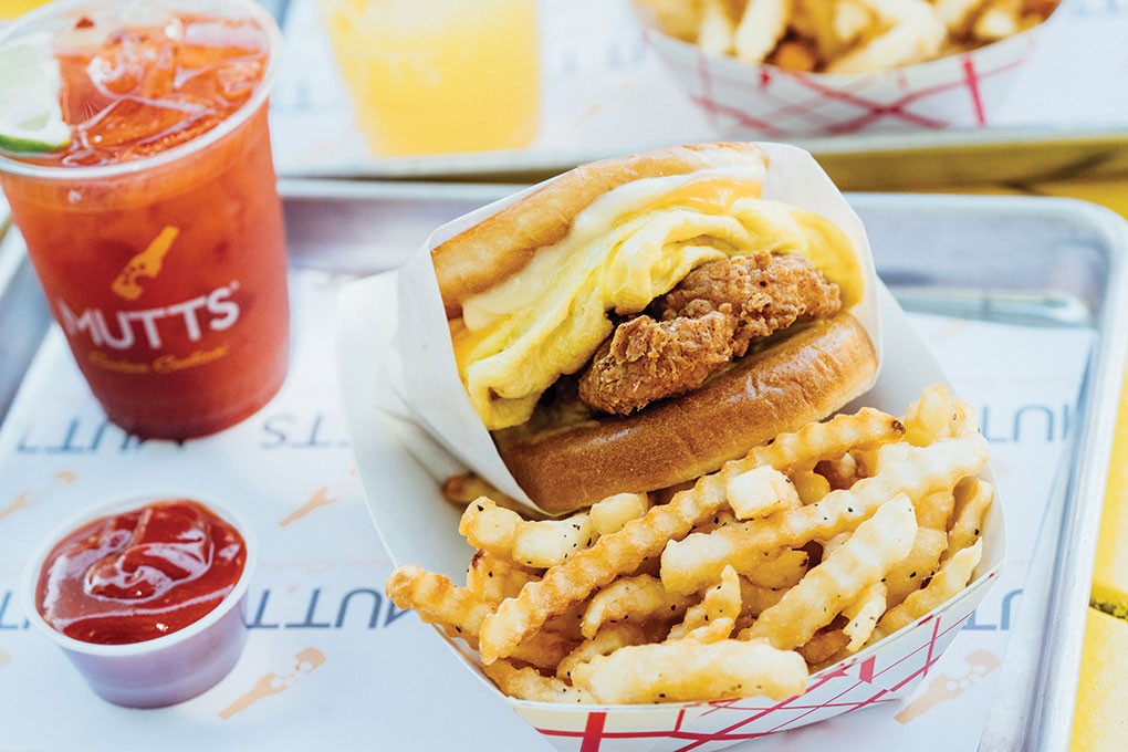 Hybrid concept Mutts Canine Cantina, based in Dallas/Fort Worth, attracts weekend guests with breakfast items like this signature Chicken, Egg & Cheese sandwich, featuring fried chicken tenders, an omelette-style egg, American cheese, pickles and Szechuan peppercorn sauce.