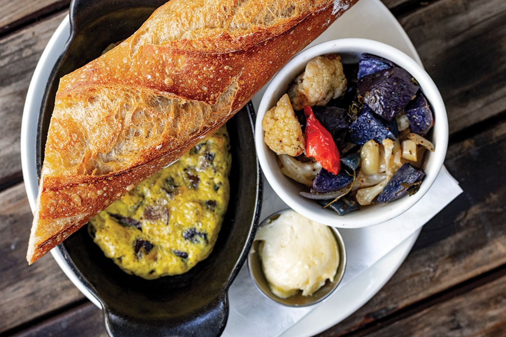 A hearty baguette and European butter accompany the Wild Mushroom & Goat Cheese Omelette at Bread Lounge in Los Angeles.