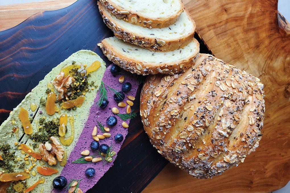 Ian Ramirez turns a classic bread basket on its head with his “Butter Board,” accompanied by artisan bread. Here, he features Blueberry Butter topped with pine nuts, blueberries and dill; and Walnut-Honey Butter with bee pollen, honey, walnuts, dried apricots and za’atar.