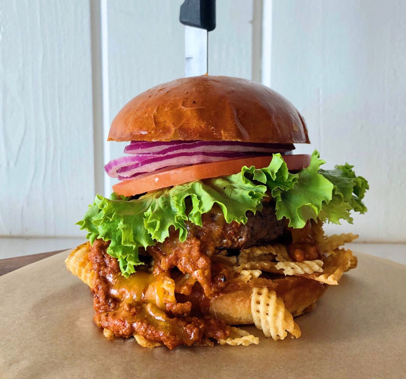 A crunchy layer of potato chips adds excitement to the Bacon Chili Crunch Burger at San Diego-based Slater’s 50/50.