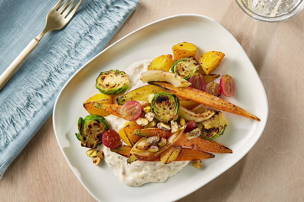 In this recipe by Chef Jennifer O’Brien, a whipped non-dairy crema is a decadent base for roasted vegetables. Roasted grapes add a pop of sweetness and pistachio clusters pack a satisfying crunch.