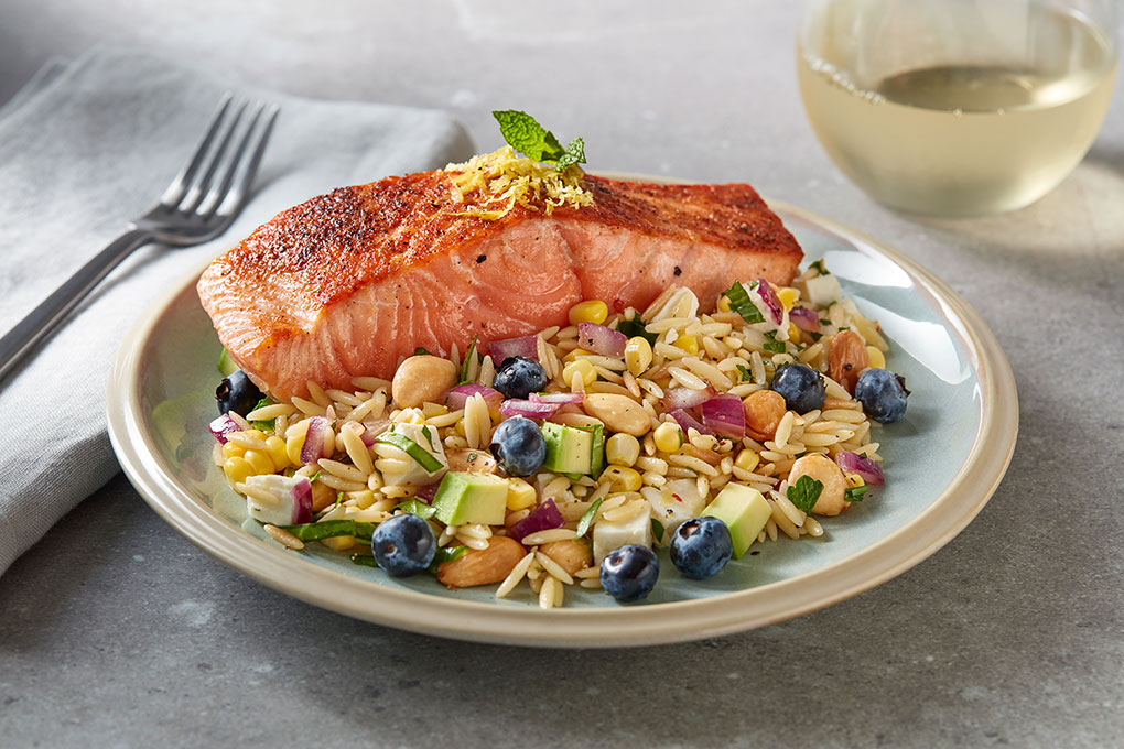 Chef Pam Smith, RD, gives pasta salad a major flavor makeover by first toasting the orzo, then cooking it in chicken stock with Creole seasoning. Studded with corn, blueberries, avocado, almonds and feta, the salad provides a flavorful base for citrus-seared salmon.