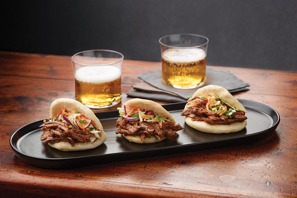 Chef/owner Rena Frost of Mac’s on Main in Grapevine, Texas, chooses Chinese bao as the carrier for her Texas-style Chile-Rubbed Lamb Bao Tacos. Ideal for to-go thanks to a sturdy structure, these “tacos” feature braised Australian lamb shoulder rubbed with espresso powder and chile de árbol.