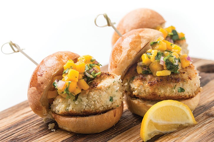 Unexpected add-ins like smoked bacon and toppings like pickled mango relish make classics such as crab cakes new again.