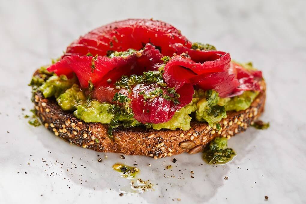 Avocado toast with beet-cured Alaska salmon and kale salsa verde