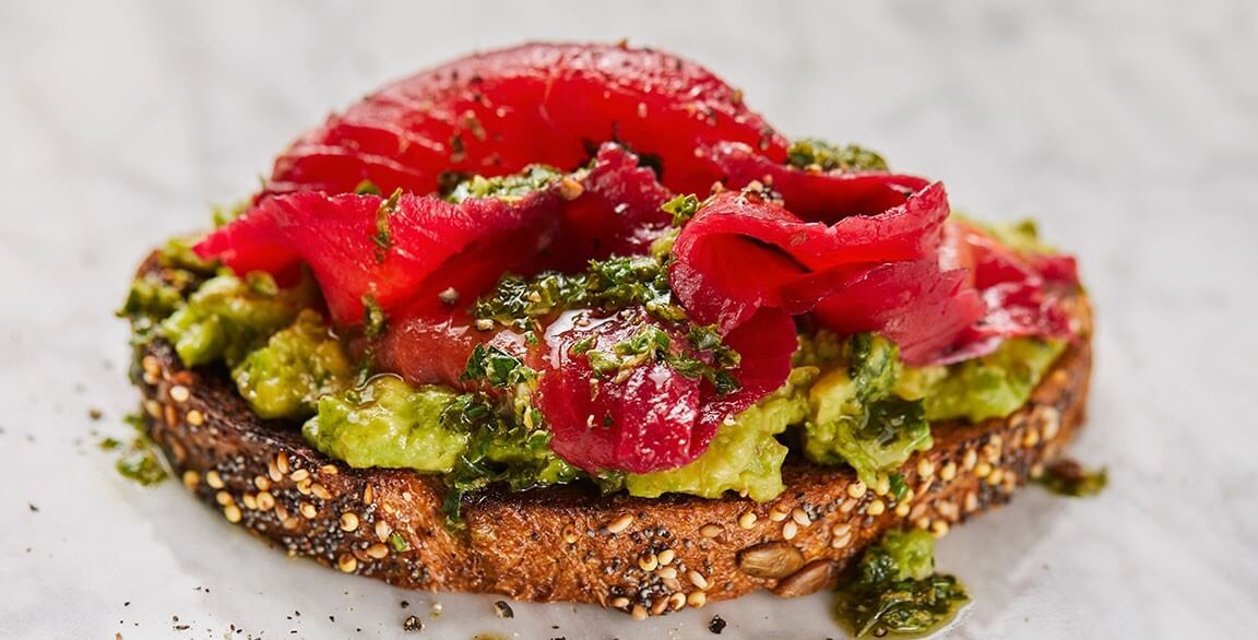 Avocado toast with beet-cured Alaska salmon and kale salsa verde