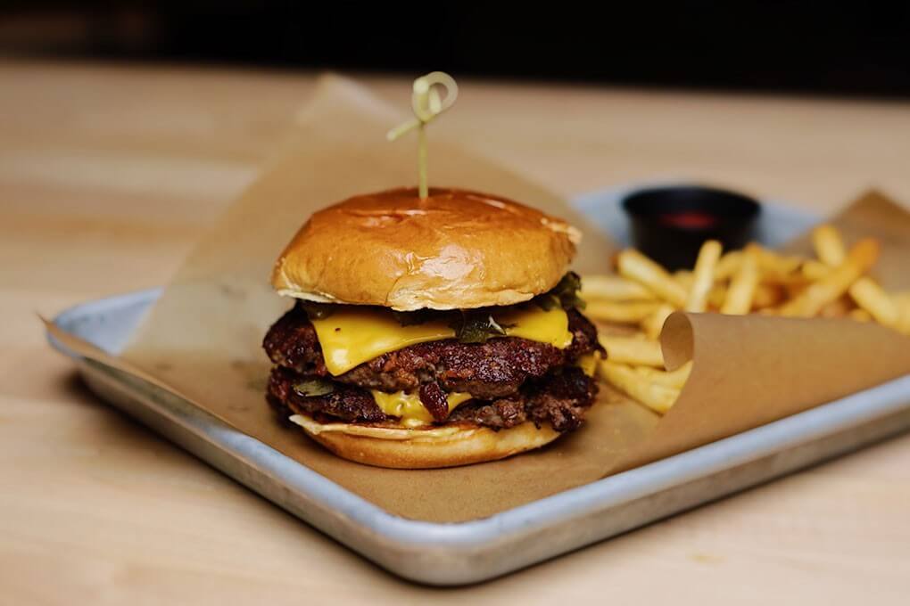 Hand-smashed patties seared with bacon, American cheese, Hatch chile peppers, caramelized onions, pickled Fresno chiles, Hatch chile aïoli, on a challah bun