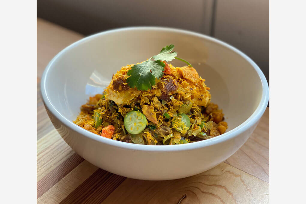 Goat Curry with fideos, topped with cilantro, green onions, mango yogurt and “crunchy snacks”