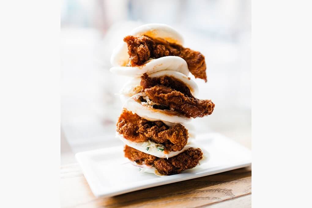 Hot Chicken Buns with Kewpie mayo slaw and a dill pickle on steamed bao buns