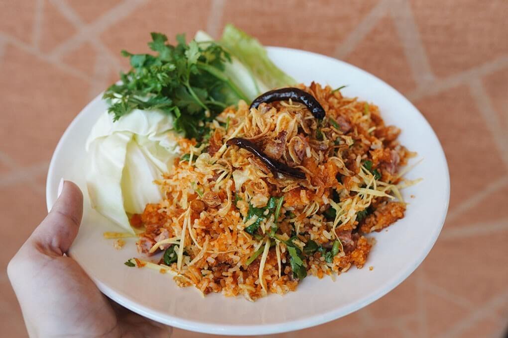 Smashed deep-fried rice cakes with chiles, fish sauce and lime, served with pork sausage, ginger, cilantro and chiles