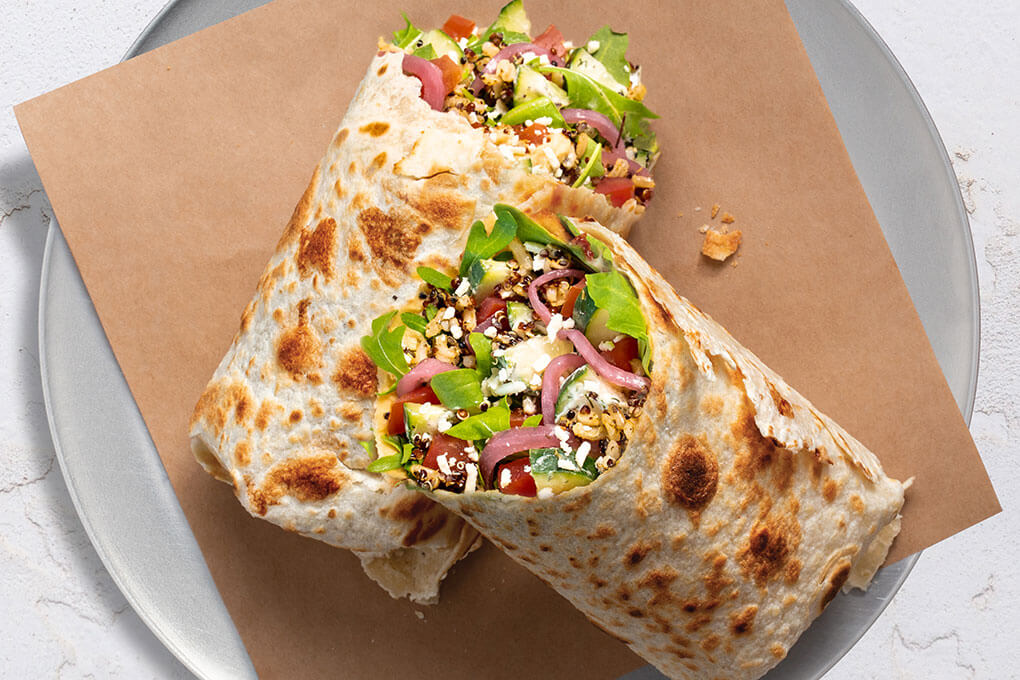 Mediterranean Piada: Garlic hummus, harissa brown rice and quinoa, cucumber salad, bruschetta tomatoes, arugula, crumbled feta and basil aïoli, wrapped in toasted piada dough