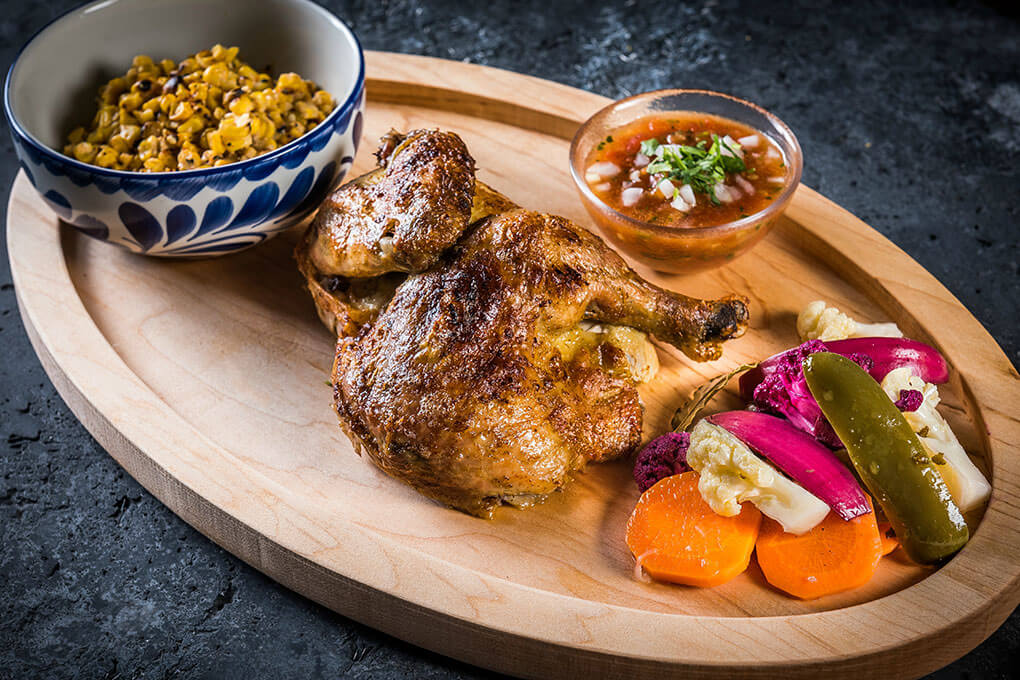 Pollo Chilango with pickled vegetables, crushed tomato salsa and roasted corn esquites